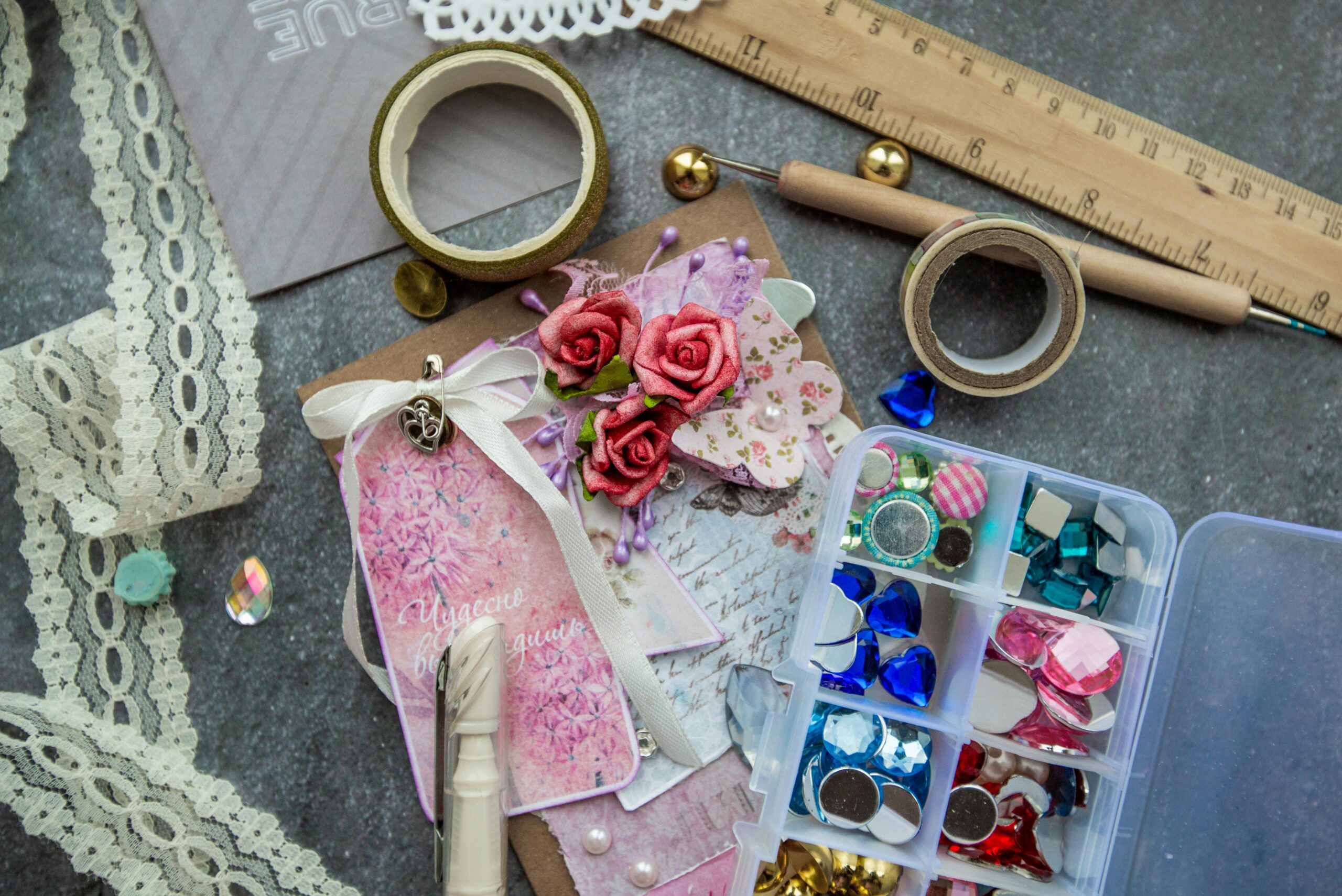 From above composition of various supplies for handicraft works placed on table with richly decorated greeting card
